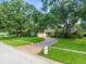 Circular brick driveway leads to a well-manicured front yard with mature shade trees at 4209 Winding Willow Dr, Tampa, FL 33618
