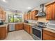 Bright kitchen features stainless steel appliances, ample wood cabinets, and a large window for natural light at 4209 Winding Willow Dr, Tampa, FL 33618