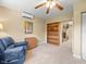 Living room with ceiling fan, blue recliner, wood cabinets and door that leads to stone fireplace room at 4209 Winding Willow Dr, Tampa, FL 33618
