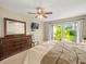 The main bedroom features neutral walls, a ceiling fan, and a large window overlooking the backyard at 4209 Winding Willow Dr, Tampa, FL 33618