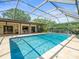 Screened-in pool with covered patio, luscious landscaping and inviting outdoor living space at 4209 Winding Willow Dr, Tampa, FL 33618