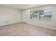 Bright living area with tile floors and ample natural light from a large window and a neutral-toned door at 4414 Royal Oak Ln, New Port Richey, FL 34653