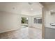 Bright living area with tile floors, neutral color, sliding glass doors to the yard, and kitchen views at 4414 Royal Oak Ln, New Port Richey, FL 34653