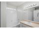 Bright bathroom with a tub-shower combo featuring white tile and an attractive vanity mirror at 456 Summer Sails Dr, Valrico, FL 33594