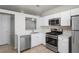 Modern kitchen featuring white cabinets, stainless steel appliances, and tile flooring at 456 Summer Sails Dr, Valrico, FL 33594
