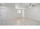 Bright living room with neutral tile flooring, a pass-through window to kitchen, and a ceiling fan at 456 Summer Sails Dr, Valrico, FL 33594