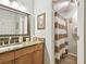 Cozy bathroom features granite countertop vanity, framed mirror, and walk-in shower with stylish striped curtain at 4984 Beach Se Dr # B, St Petersburg, FL 33705