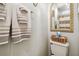 Bathroom featuring a toilet with storage basket, elegant towels, and decorative mirror at 4984 Beach Se Dr # B, St Petersburg, FL 33705