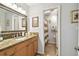 Bathroom featuring granite countertop vanity, decorative mirror, and walk-in shower with stylish striped curtain at 4984 Beach Se Dr # B, St Petersburg, FL 33705