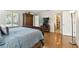 Bright bedroom featuring hardwood floors, large bed, shutters, armoire, and an ensuite bathroom at 4984 Beach Se Dr # B, St Petersburg, FL 33705