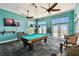 Well lit game room with a pool table, ceiling fans, french doors and tropical decorations at 4984 Beach Se Dr # B, St Petersburg, FL 33705
