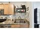 Bright kitchen featuring granite countertops, modern backsplash, and organized shelving for wine and glassware at 4984 Beach Se Dr # B, St Petersburg, FL 33705