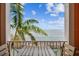Balcony view showing the ocean and a fishing pier with a small table and chairs at 4984 Beach Se Dr # B, St Petersburg, FL 33705