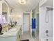 Bathroom with dual sinks, a shower with tile surround, and a decorative chandelier at 5200 Brittany S Dr # 1501, St Petersburg, FL 33715