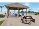 Poolside outdoor area with picnic tables, chairs, and a tiki hut overlooking the water at 5200 Brittany S Dr # 1501, St Petersburg, FL 33715
