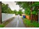 A quiet back alley offers privacy and access to the property, lined with lush greenery at 5628 2Nd N Ave, St Petersburg, FL 33710