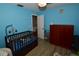 Blue bedroom with luxury vinyl plank floor, dresser, and crib at 5628 2Nd N Ave, St Petersburg, FL 33710