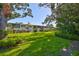 The backyard features lush green grass, mature trees, and landscaping at 5695 40Th N Ave # 301, Kenneth City, FL 33709
