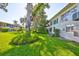 Backyard view shows the grassy lawn, mature trees, and the building exterior at 5695 40Th N Ave # 301, Kenneth City, FL 33709
