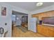 Open kitchen with wood cabinets, white appliances, and a view into the dining area at 5695 40Th N Ave # 301, Kenneth City, FL 33709