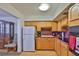 Bright kitchen with wooden cabinets, white refrigerator, and view to adjacent room at 5695 40Th N Ave # 301, Kenneth City, FL 33709