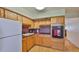 Kitchen featuring wooden cabinets, oven and white refrigerator at 5695 40Th N Ave # 301, Kenneth City, FL 33709
