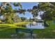 Scenic view of a community pond with a fountain, mature trees, and a park bench at 5695 40Th N Ave # 301, Kenneth City, FL 33709