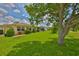 Spacious backyard with lush green grass and mature trees offering a serene outdoor living space at 608 Fort Duquesna Dr, Sun City Center, FL 33573