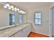 Bright bathroom featuring granite countertops, white cabinetry, and a large mirror for a clean, modern look at 608 Fort Duquesna Dr, Sun City Center, FL 33573