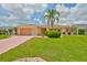Inviting single-story home with manicured lawn, colorful shrubs and mature palm tree at 608 Fort Duquesna Dr, Sun City Center, FL 33573