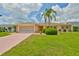 Charming single-story home with a well-manicured lawn and mature palm tree at 608 Fort Duquesna Dr, Sun City Center, FL 33573