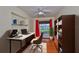 Functional home office featuring a built in desk, shelving, wood floors, and natural lighting at 608 Fort Duquesna Dr, Sun City Center, FL 33573