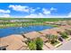 Expansive aerial view of tile-roofed villas surrounding a picturesque lake and greenery at 6327 Positano Ct, Sarasota, FL 34243