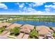 Aerial view of the villas surrounding a serene lake with lush landscaping and clear blue skies at 6327 Positano Ct, Sarasota, FL 34243