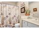 Bathroom featuring a white vanity, decorative shower curtain, and coastal decor at 6327 Positano Ct, Sarasota, FL 34243
