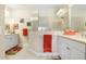Bright bathroom with double sinks, white cabinets, a glass enclosed shower, and coastal decor at 6327 Positano Ct, Sarasota, FL 34243