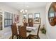 Charming dining room with a glass-top table, seating for six, and decorative artwork at 6327 Positano Ct, Sarasota, FL 34243