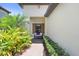 Inviting front porch with a comfortable bench, lush landscaping, and a brick walkway at 6327 Positano Ct, Sarasota, FL 34243