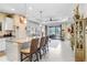 Open living space with kitchen island, tray ceiling, ceiling fan, and view to outdoor seating area at 6327 Positano Ct, Sarasota, FL 34243