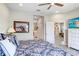 Bright primary bedroom featuring en-suite bathroom access, ceiling fan, and large windows at 6327 Positano Ct, Sarasota, FL 34243