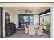 Covered patio featuring comfortable wicker chairs, a glass table, and an outdoor grill at 6327 Positano Ct, Sarasota, FL 34243