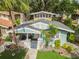An aerial shot of the home displaying landscaping, a small patio, and a quaint covered porch at 711 S Bungalow Ter, Tampa, FL 33606