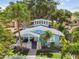 Aerial view of the charming blue home with lush landscaping and stone accents at 711 S Bungalow Ter, Tampa, FL 33606