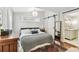Bright bedroom featuring light walls, dark furniture, and a sliding barn door at 711 S Bungalow Ter, Tampa, FL 33606