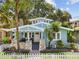 Charming blue two-story home with stone accents, white picket fence, and lush landscaping at 711 S Bungalow Ter, Tampa, FL 33606