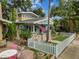 Charming front exterior with stone accents, a white picket fence, manicured lawn and an inviting facade at 711 S Bungalow Ter, Tampa, FL 33606