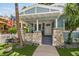 Inviting covered front porch with stone pillars and seating area on blue house at 711 S Bungalow Ter, Tampa, FL 33606