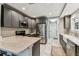 Stylish kitchen featuring stainless steel appliances, gray cabinetry, and a marble countertop island at 711 S Bungalow Ter, Tampa, FL 33606