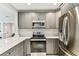 Kitchen featuring gray cabinets, marble countertops and stainless steel appliances at 711 S Bungalow Ter, Tampa, FL 33606