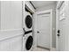 Convenient laundry area featuring a stacked washer and dryer, and white doors for an updated, clean aesthetic at 711 S Bungalow Ter, Tampa, FL 33606